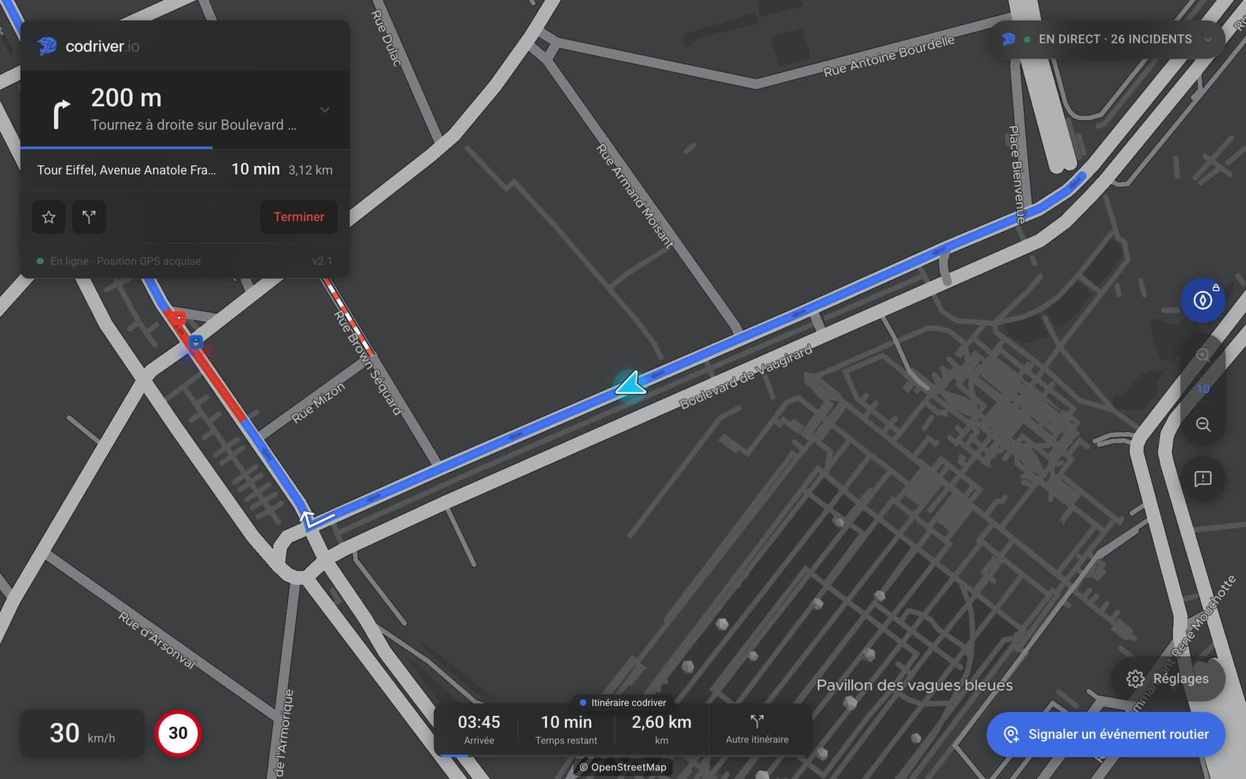 La carte codriver en vue Boussole sur l’écran d’une Tesla, en cours d’itinéraire, la voiture sur sa ligne et les noms de rue posés le long des voies. — interface en français