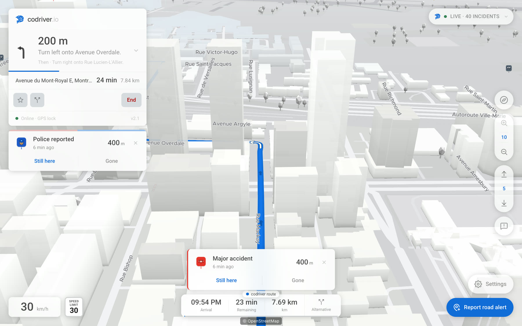 The codriver app on a Tesla screen at night in downtown Montreal: a card names a police report a few hundred metres ahead, with Still here and Gone buttons, above the route running between the buildings.